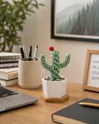 Handmade macrame cactus in white ceramic pot with crystal chips on bamboo tray on wooden desk beside laptop and pen cup, boho desk decor gift