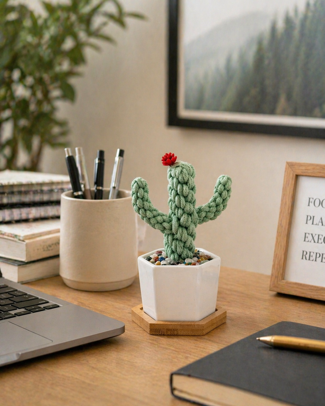 Handmade macrame cactus in white ceramic pot with crystal chips on bamboo tray on wooden desk beside laptop and pen cup, boho desk decor gift