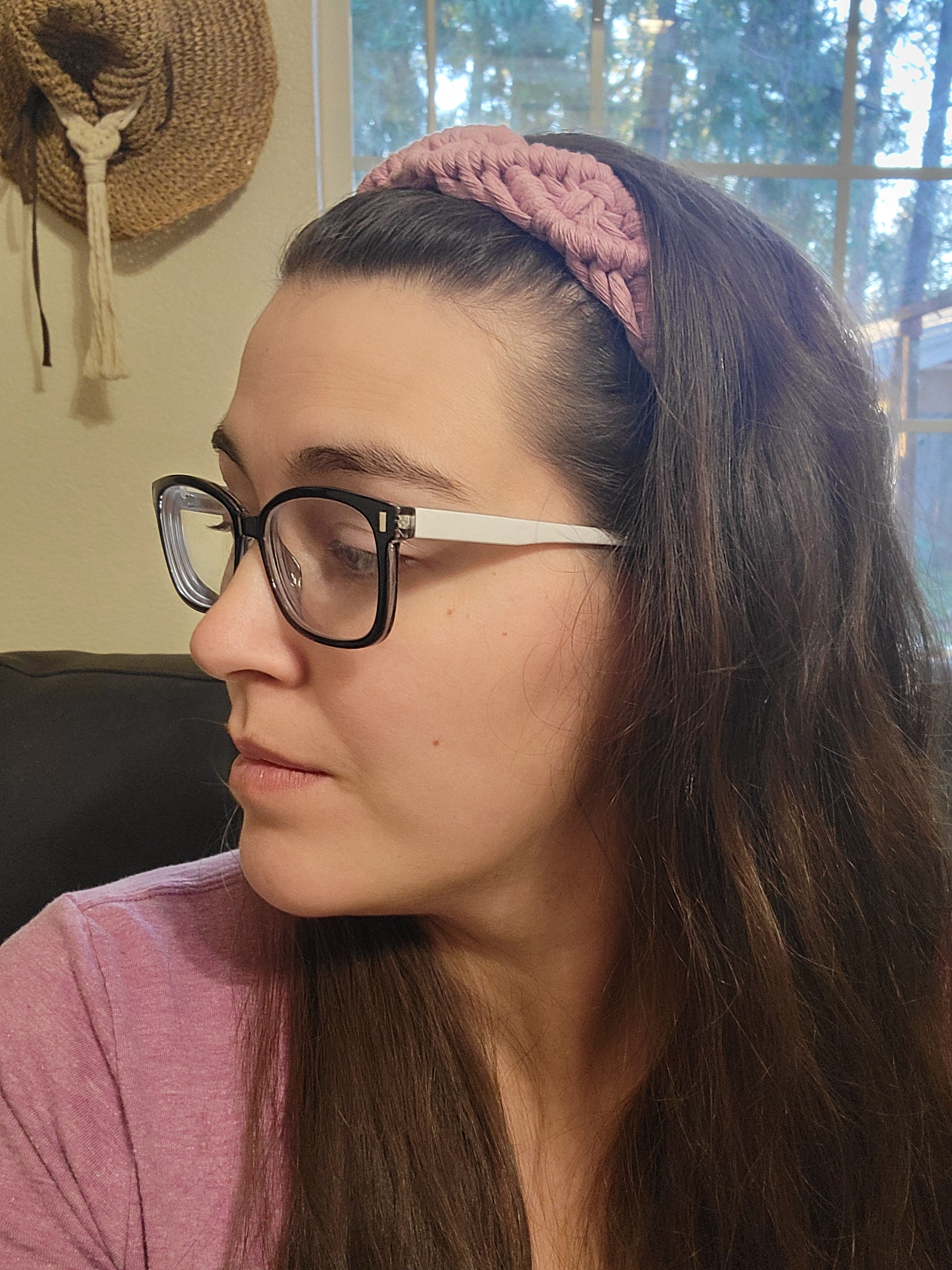 Woman wearing glasses and a pink headband with a blurred background
