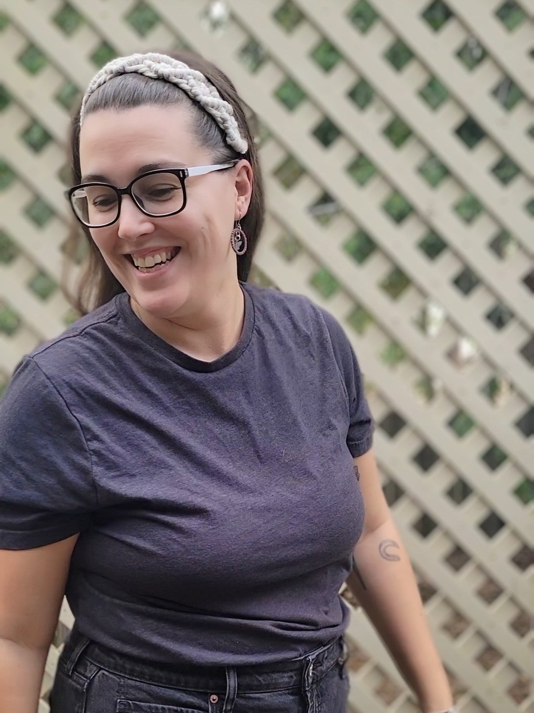 Woman wearing a gray macramé braided headband with adjustable elastic back, styled in a half-up hairstyle
